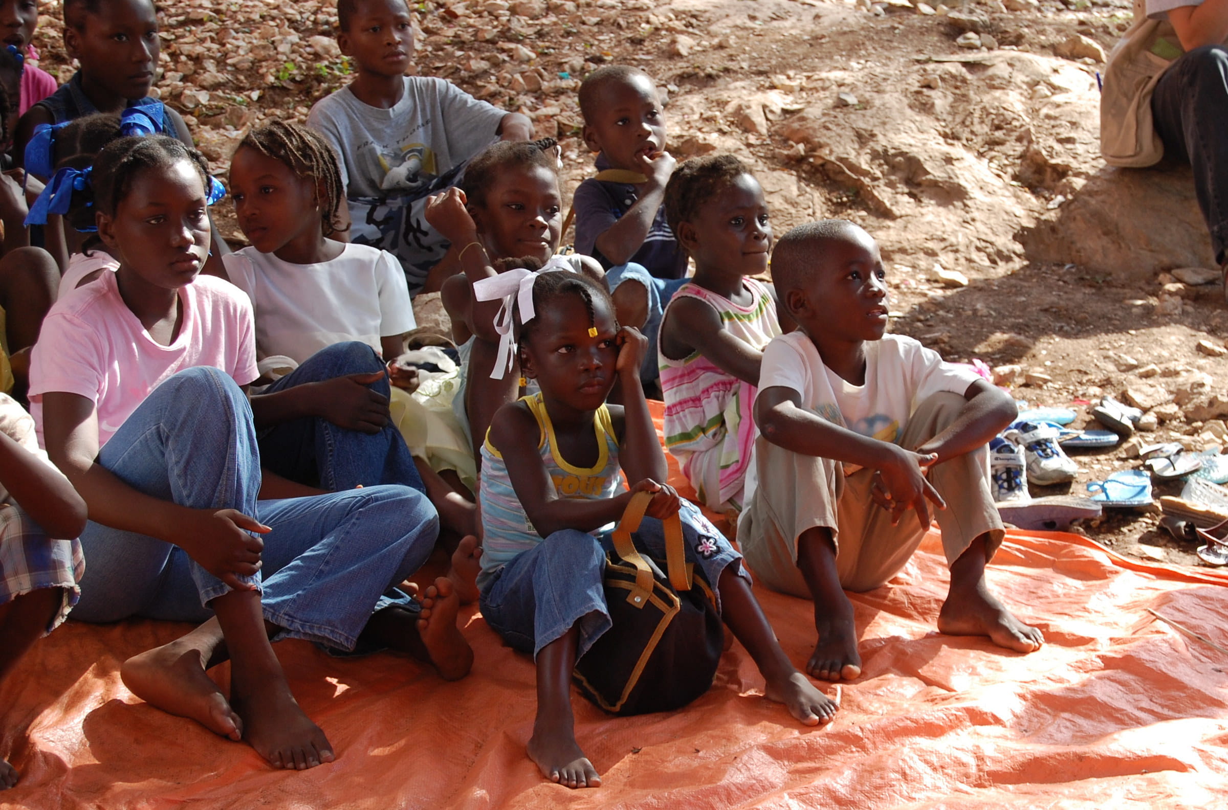 Mädchen und Jungen aus Haiti sitzen auf dem Foto. Fast die Hälfte der knapp drei Millionen Mädchen und Jungen leidet unter akutem Hunger. Schulen sind geschlossen und die Gewalt gegen Kinder nimmt verheerende Ausmaße an. (Foto: Erhard Stückrath/Kindernothilfe)