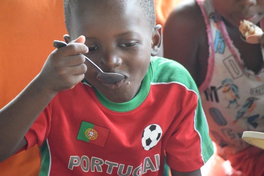 Humanitäre Hilfe - Child Friendly Spaces nach dem Erdbeben am 14.08.2021 im Süden Haitis: Junge isst gemeinsam mit anderen Kindern