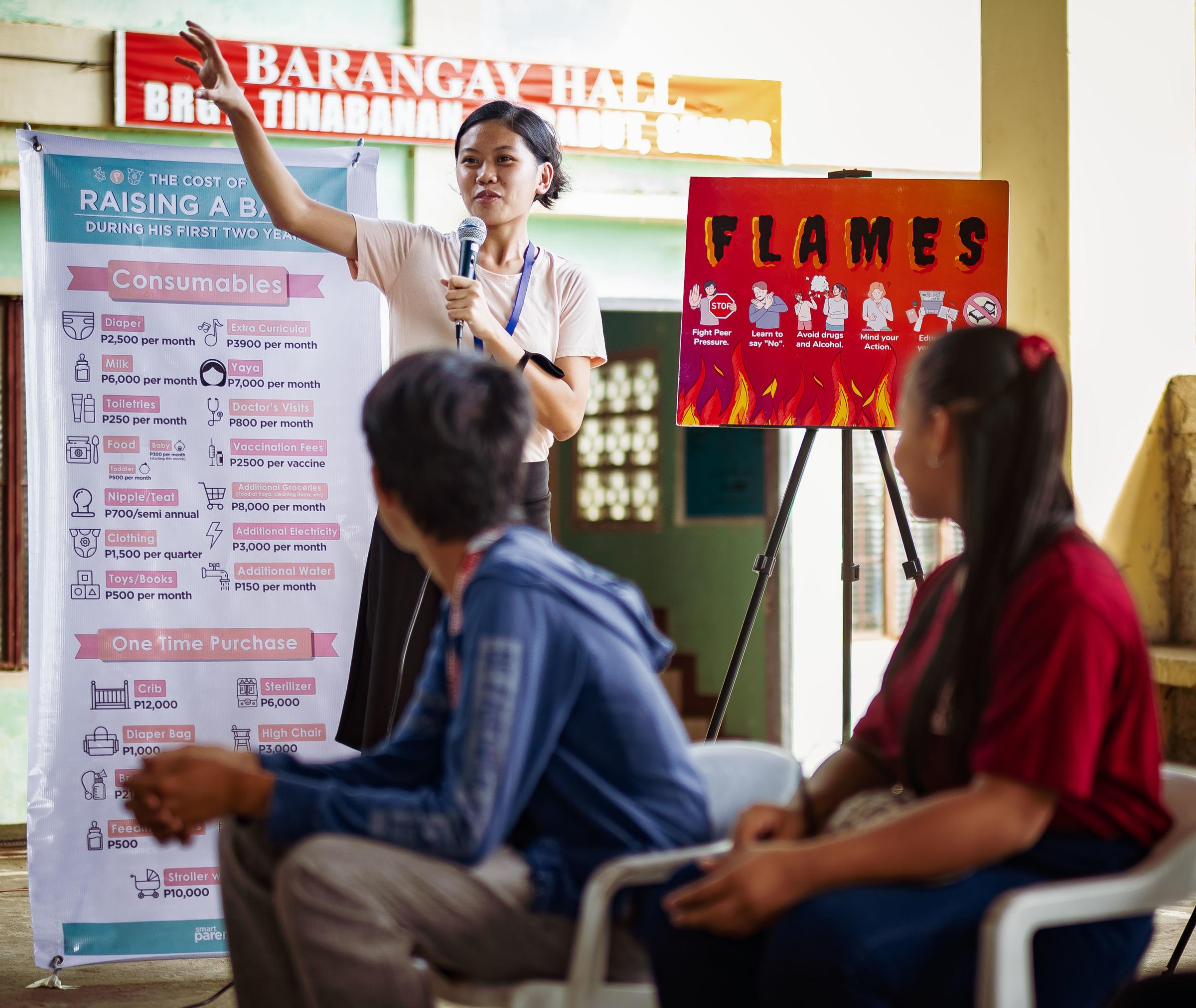 Eine junge Frau steht neben einer Flipchart und erklärt Jugendlichen etwas (Quelle: Jakob Studnar) Eine junge Frau steht neben einer Flipchart und erklärt Jugendlichen etwas (Quelle: Jakob Studnar)