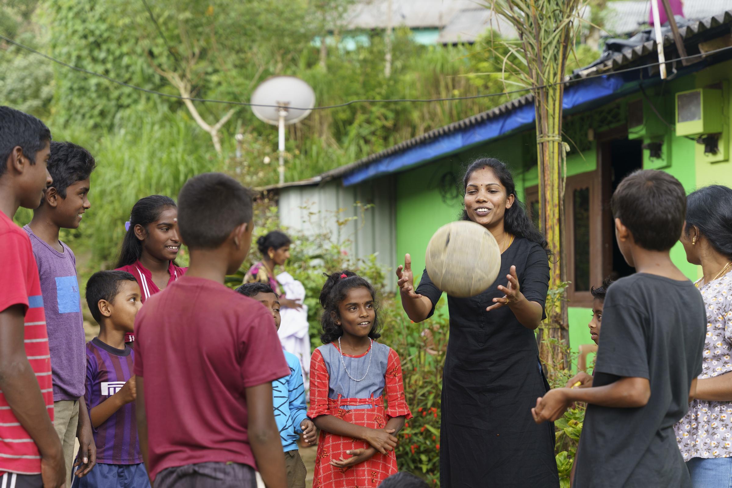 Eine Mitarbeiterin eines Kindernothilfepartners spielt mit Kindern Ball (Quelle: Christian Nusch) TLV-Mitarbeiterin Aruniya ist sehr zuversichtlich, was die Zukunft der Kinder und Familien in dieser Siedlung angeht (Foto: Christian Nusch)