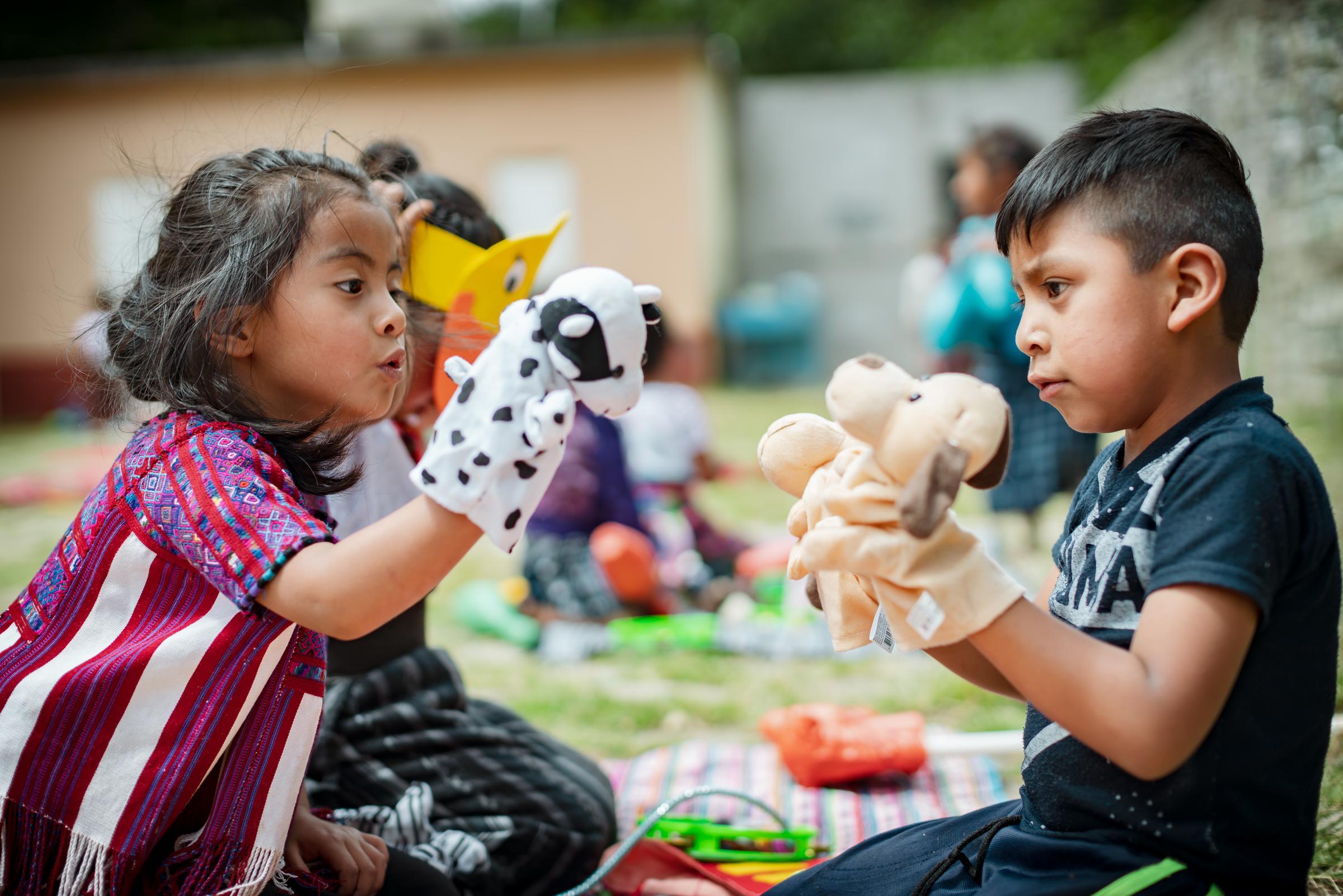 Vorschulkinder im Kindernothilfeprojekt in Guatemala sitzen sich gegenüber und spielen mit Handpuppen (Quelle: Jakob Studnar) Vorschulkinder im Kindernothilfeprojekt in Guatemala sitzen sich gegenüber und spielen mit Handpuppen (Quelle: Jakob Studnar)