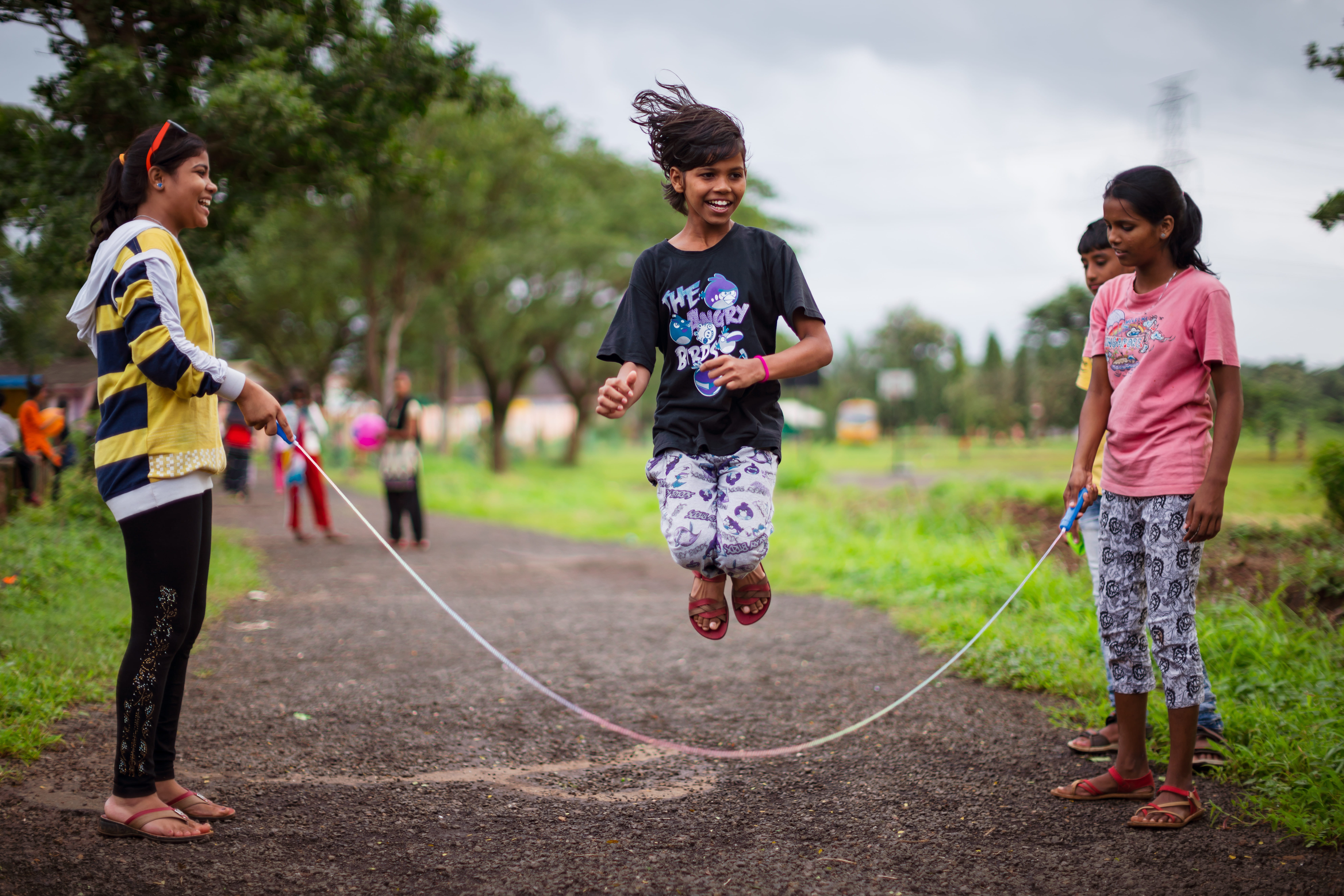 Drei Mädchen aus Indien springen lachend Seilchen. (Quelle: Jakob Studnar)
