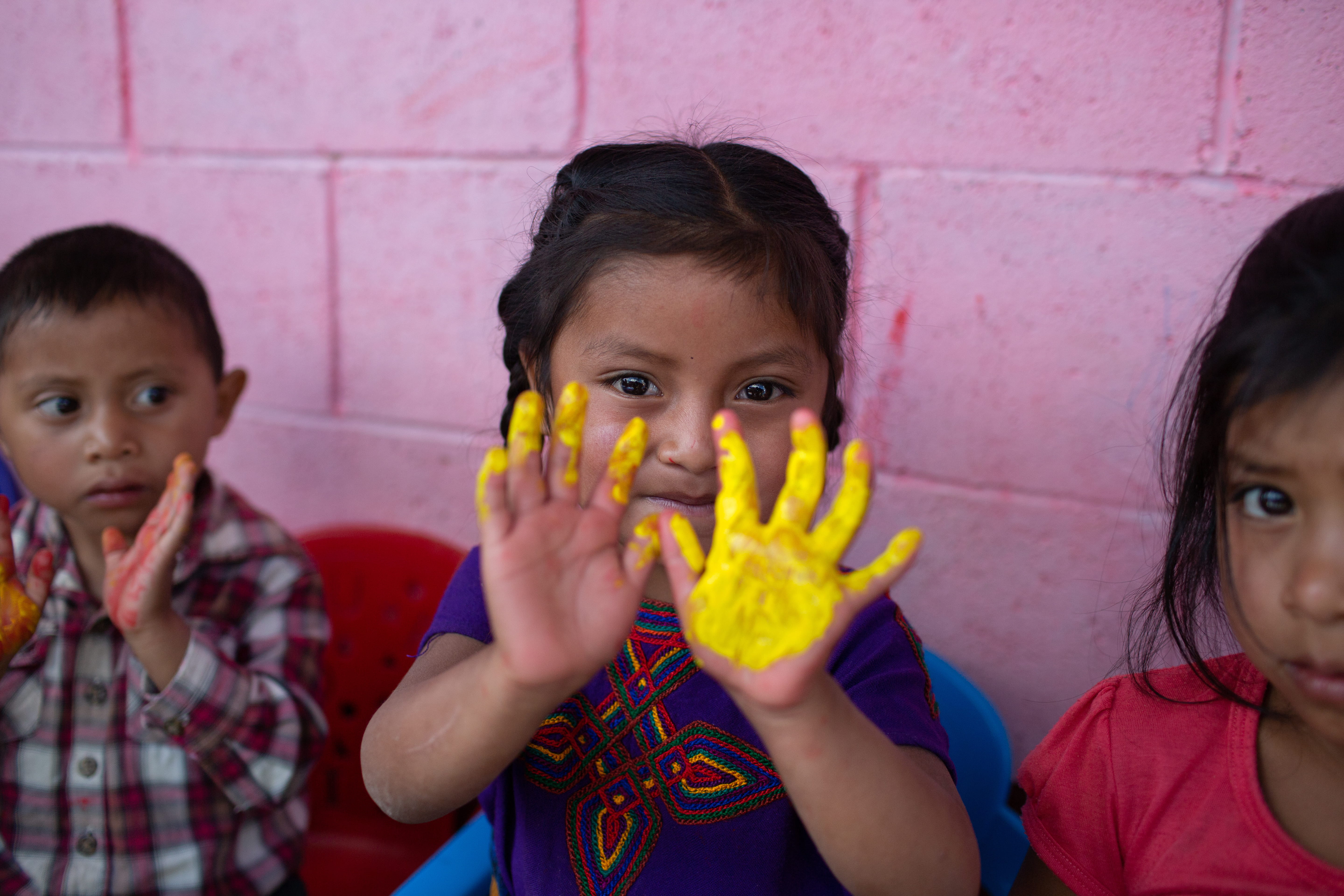 Mädchen mit angemalten gelben Händen (Quelle: James Rodriguez)