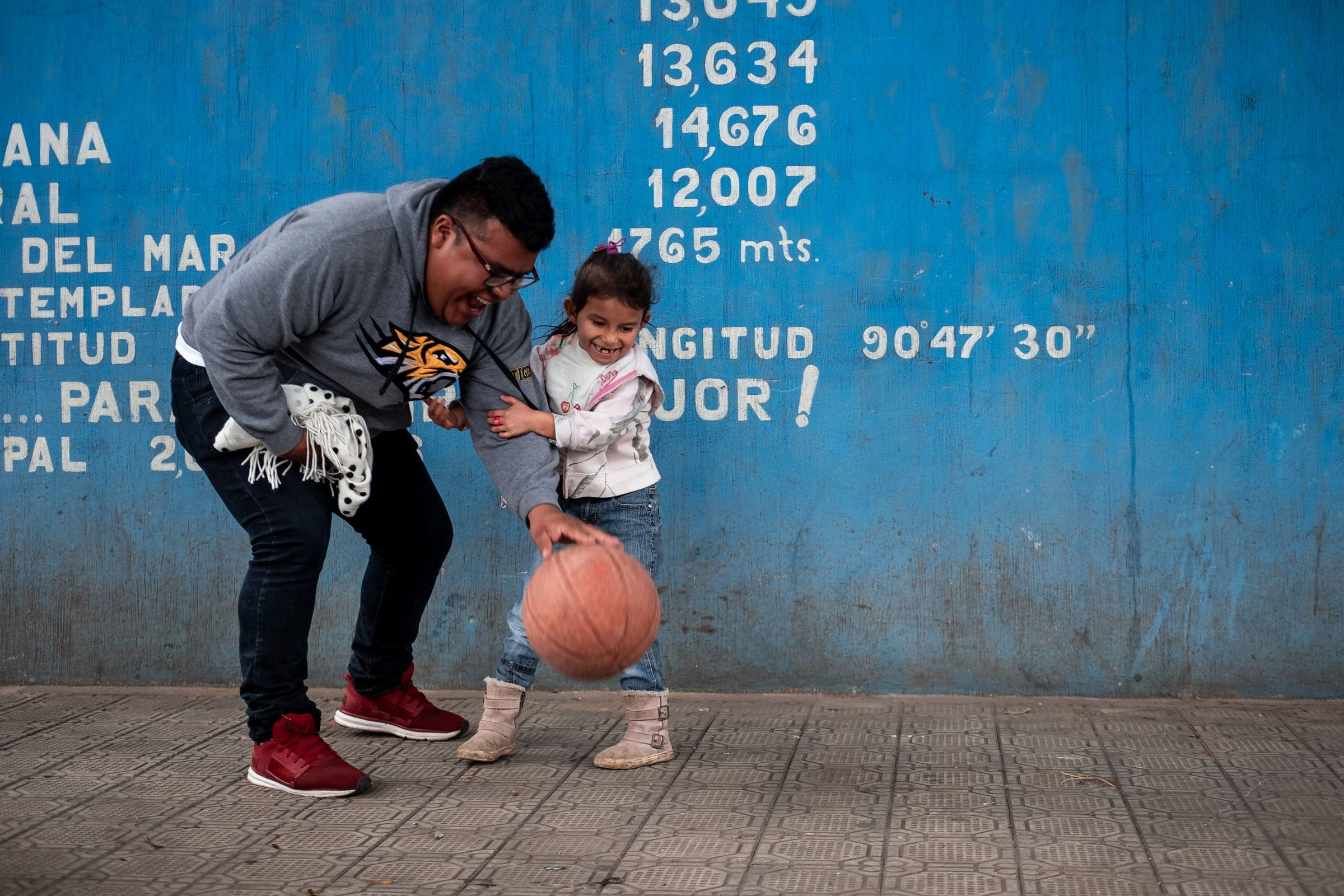 Ein Mann und ein kleines Mädchen in Bolivien spielen mit einem Ball. (Quelle: Fabian Strauch)